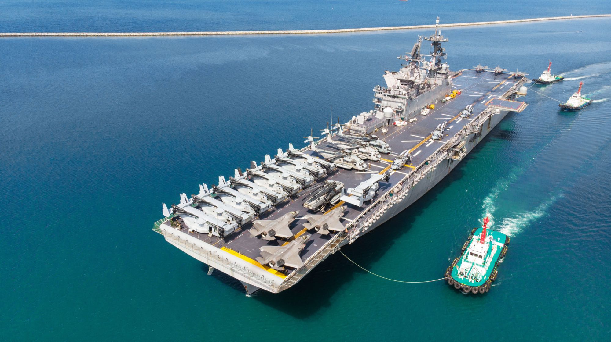 Aircraft carrier under tow into port